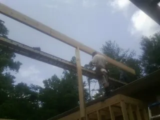 Carpenter setting a ridge beam over a new addition frame — Ice Dam Removal by Roofing Brothers in Valyermo